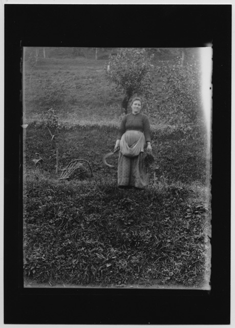 Ritratto di donna con falcetto in un prato