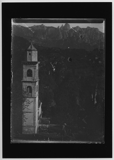 Veduta sul campanile di Bidogno con i Denti della Vecchia sullo sfondo