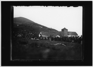 Persone riunite davanti alla chiesa di San Lucio per l'arrivo della processione