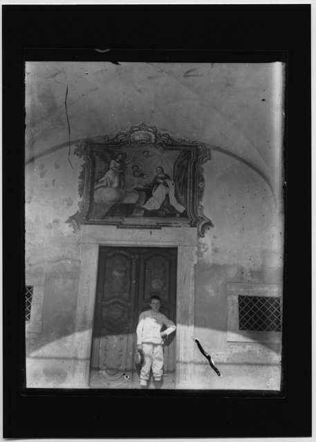 Ragazzo davanti all'Oratorio di Santa Maria delle Grazie a Bidogno