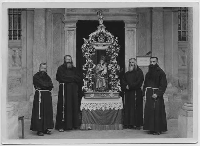 Quattro frati attorno alla statua della Madonna del Sasso
