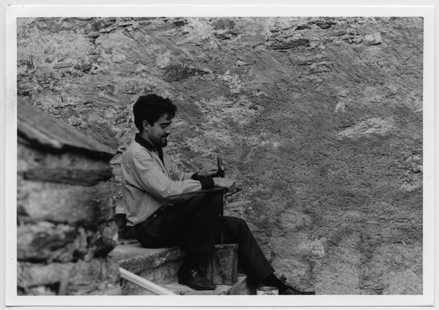 Ritratto di uomo che martella una falce durante i campi di lavoro