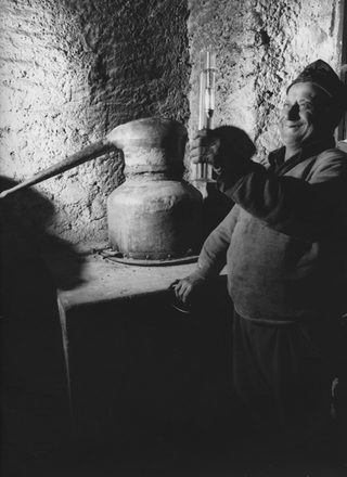 Uomo durante la distillatura della grappa