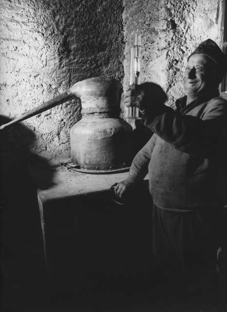 Uomo durante la distillatura della grappa