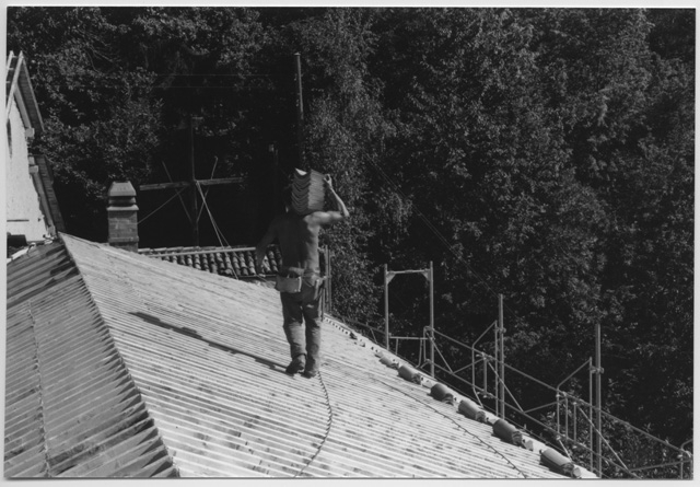 Operaio trasporta tegole sul tetto del Convento di Bigorio
