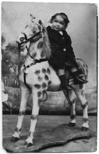 Pia Talamona ritratta su un cavallo di legno