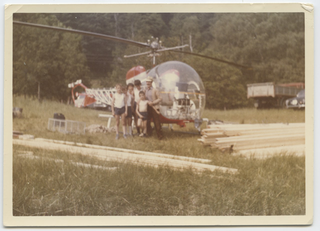 Ritratto di uomo con bambini davanti a un elicottero