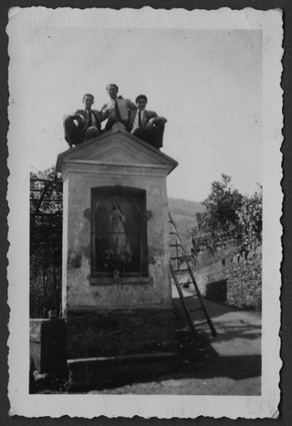 Tre ragazzi seduti in cima alla cappella di Campestro