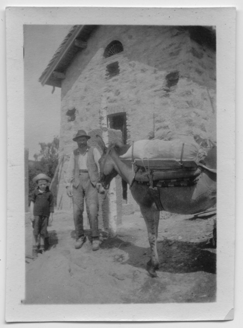 Uomo con un bambino e un mulo davanti all'oratorio di Condra