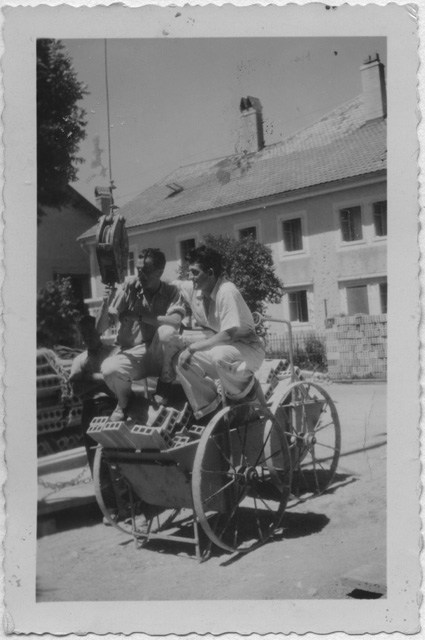 Due giovani trasportano dei mattoni con un carretto