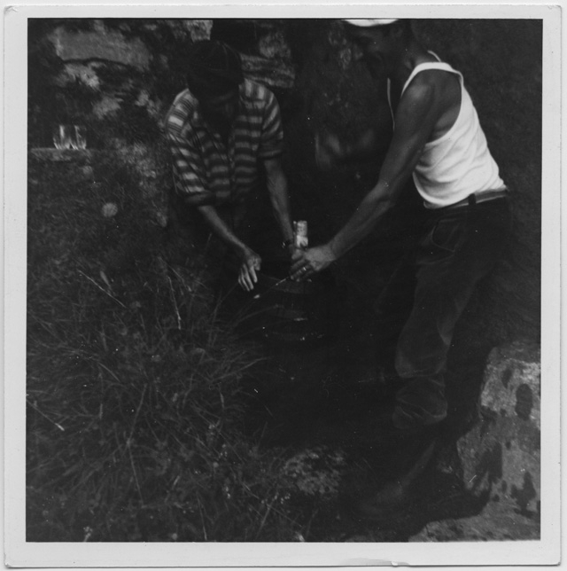 Due uomini mentre spillano del vino da una botte