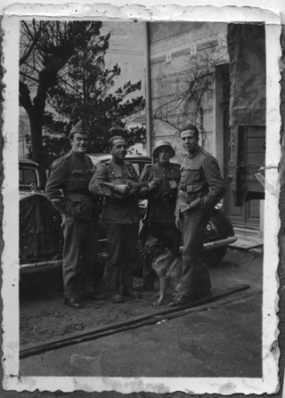 Gruppo di soldati in posa con un cane