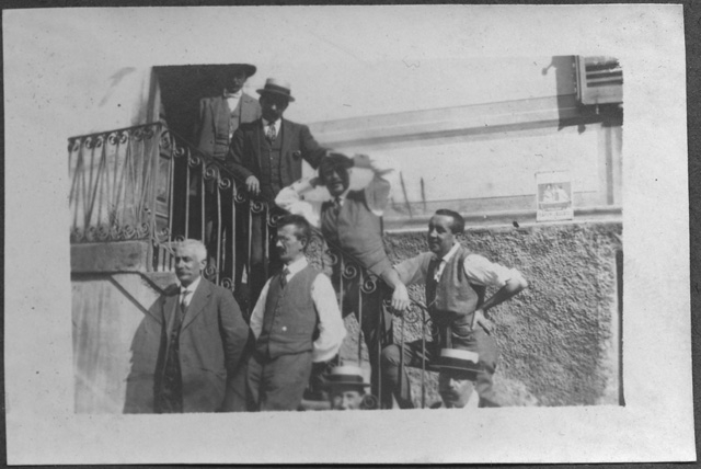 Gruppo di uomini in posa davanti all'entrata di un edificio