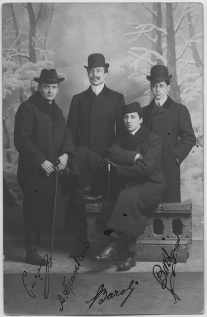 Quattro uomini in posa con bastone e cappello