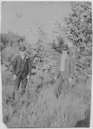 Due uomini in un prato con completo e bombetta