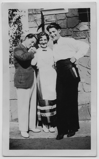 Angelo Rossini in divisa da cameriere in posa con una coppia