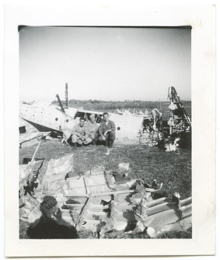 Tre militari in posa con i rottami di un aereo