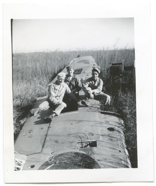 Soldati in posa sopra l'ala di un aereo