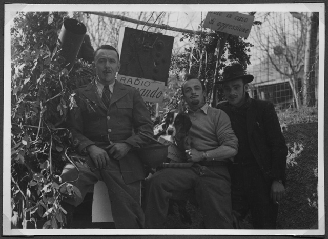 Gruppo mascherato in posa con un cane