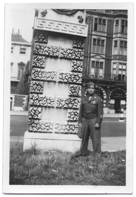 Soldato in posa accanto ad un monumento