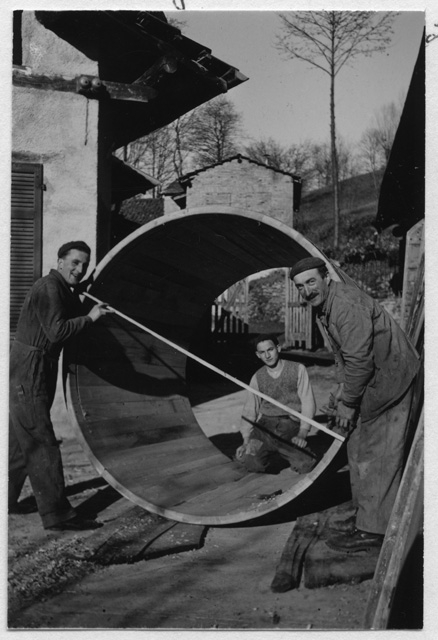 Carlo Quadri con due falegnami mentre costruiscono un tino per il vino