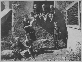 Bambini davanti ad una casa a Comano