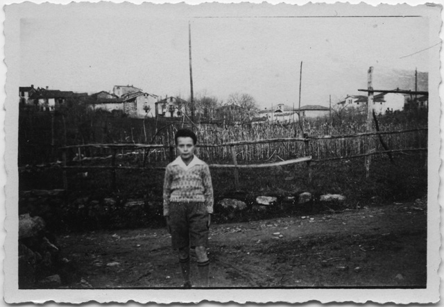 Bambino in posa davanti ad un vigneto a Comano