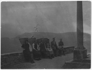 Gruppo di donne con la gerla davanti alla chiesa di Bidogno