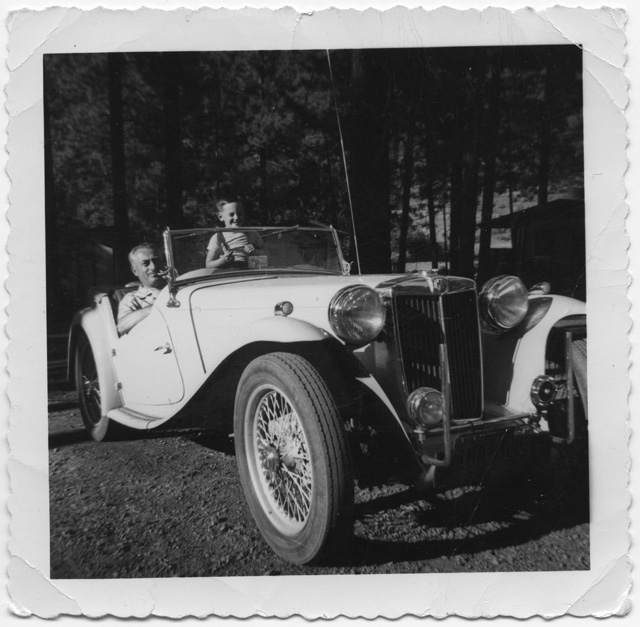 Uomo con bambino in posa a bordo di un'automobile