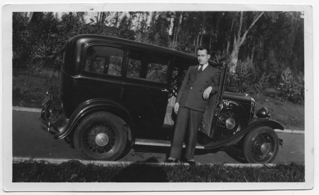 Uomo in posa davanti ad un'automobile