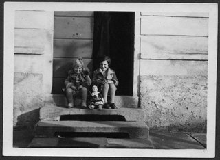 Bambine sedute sulla soglia di casa