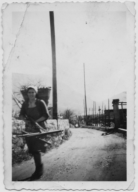 Anna Petrini con gerla e rastrello in via Ca da Runch a Comano