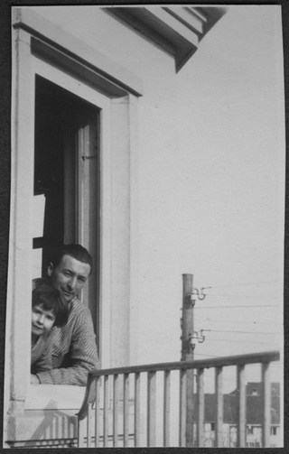 Mario Bernasconi affacciato a una finestra con una bambina