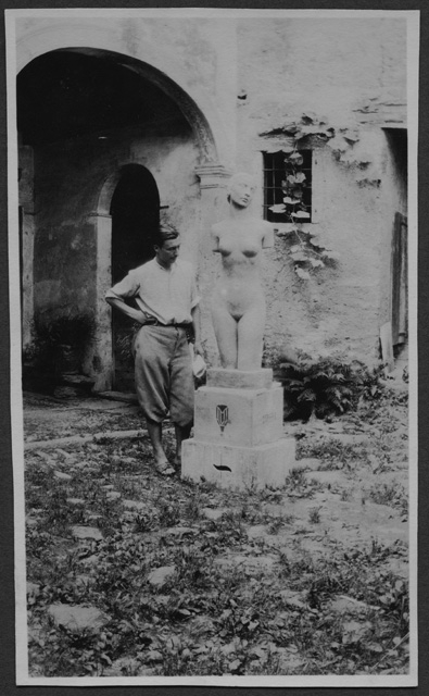 Mario Bernasconi osserva un torso da lui realizzato davanti alla propria casa