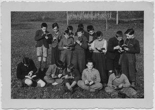 Bambini che leggono sopra a un prato