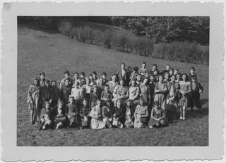 Classe scolastica in posa sopra a un prato