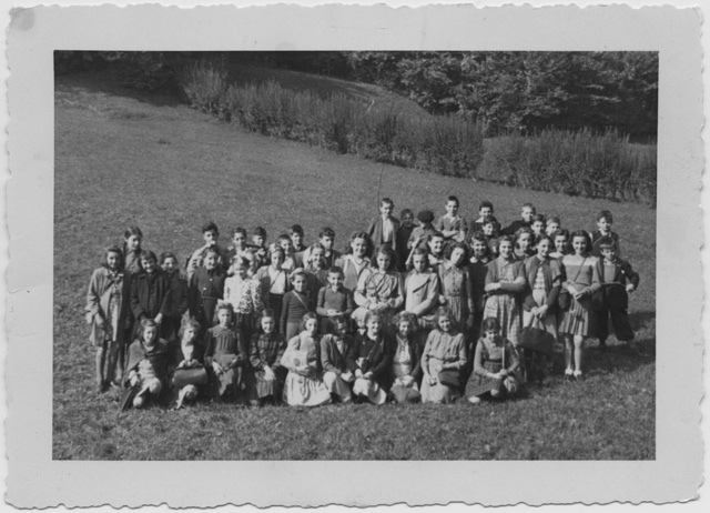 Classe scolastica in posa sopra a un prato