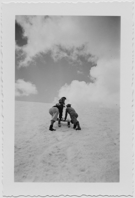 Tre persone che trainano una slitta in montagna