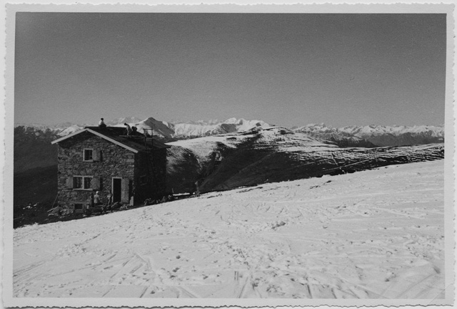 Uomini al lavoro durante la posa del tetto della capanna del Monte Bar