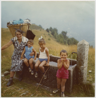 Pierina Bricalli con bambini alla fontana della Piazzàscia durante la salita verso l'alpe Pianca Bella