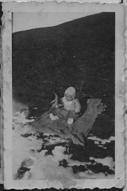 Bambino seduto sopra a un prato