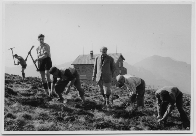 Uomini mentre dissodano il terreno alle spalle della Capanna del Monte Bar