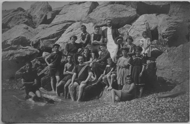 Gruppo di persone sugli scogli al mare in costume da bagno