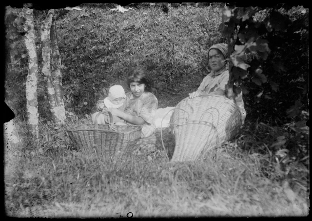 Donna con bambine in una radura con cesto e cargansch