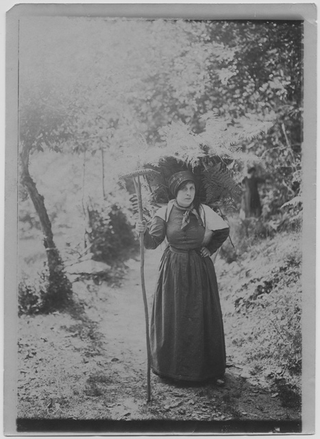 Donna con gerla e rastrello in costumi valcollini