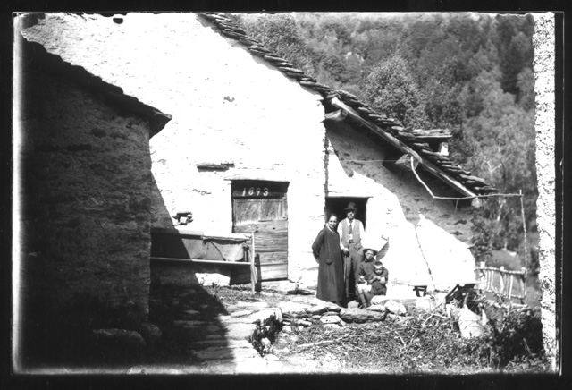 Famiglia in posa davanti ad una cascina a Gola di Lago