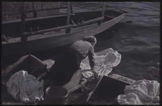 Donna mentre fa il bucato sulle rive del Cassarate