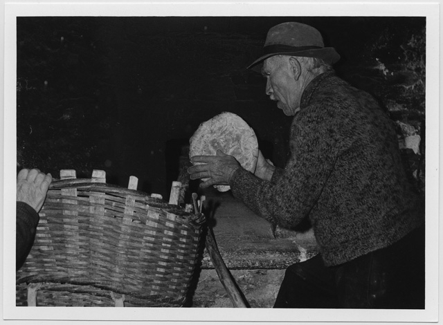 Uomo mentre sforna delle pagnotte a Sonogno