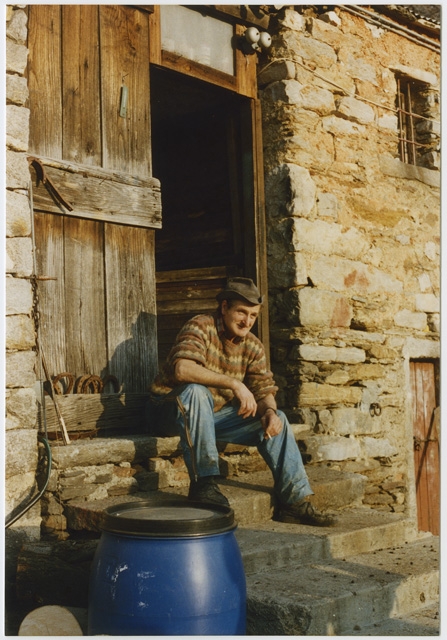 Uomo seduto sulla soglia di una cascina