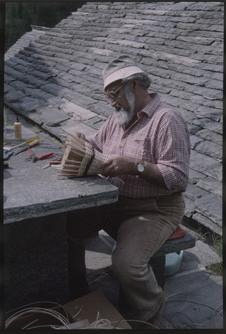 Uomo mentre intreccia un cestino di vimini